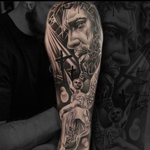 Realistische tattoo van Jezus en een engel op de bovenarm.
