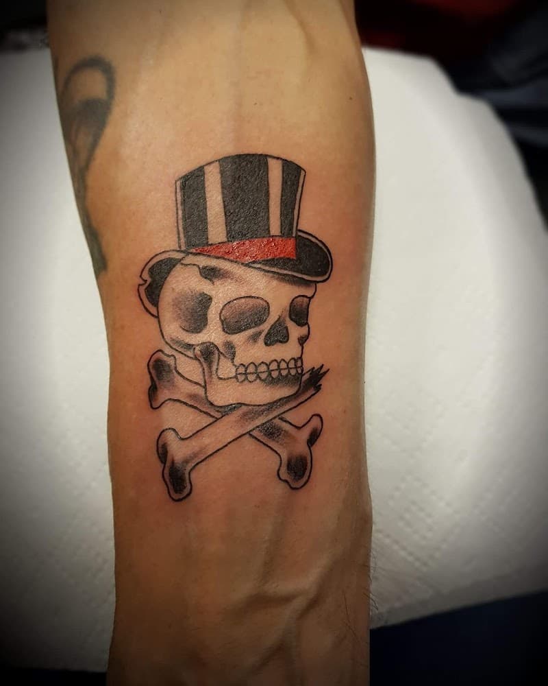 Schedel met hoge hoed en gekruiste botten op onderarm.