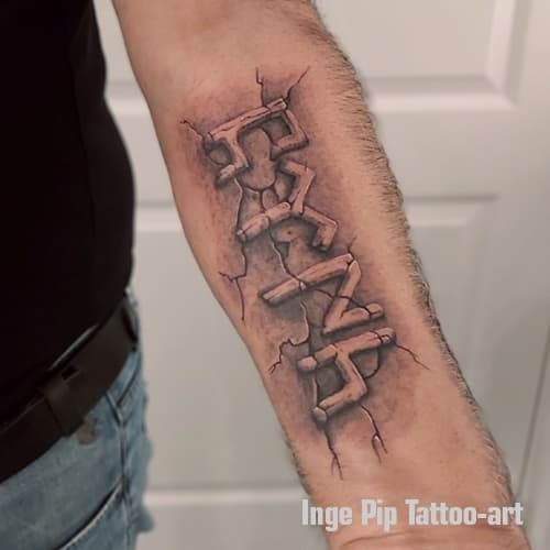 Realistische 'FAITH' tekst in gebarsten steen op onderarm.