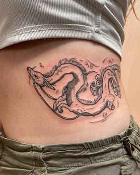Fineline tattoo van Haku de draak uit Spirited Away op de ribben.