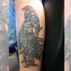 Gedetailleerde Spartaanse krijger tattoo op een schedel, met rode helmpluim.