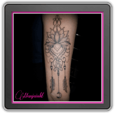 Fineline lotus met ornamenten, veren en maantje op onderarm.