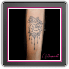 Fineline roos met mandala bladeren en hangende parels op onderarm.