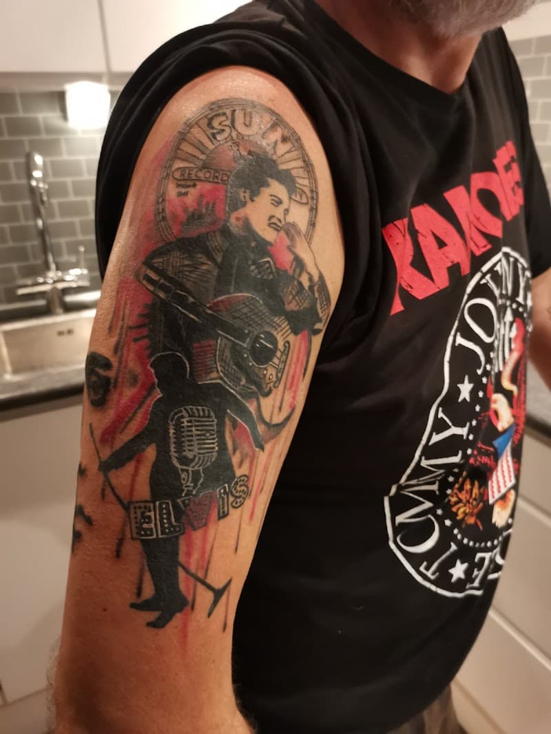 Elvis Presley Sun Records tattoo met silhouet en gitaar op bovenarm.