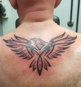 Tribale adelaar tattoo op de bovenrug.