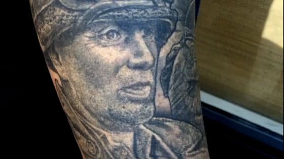 Realistisch portret van een soldaat in zwart-wit op de bovenarm.