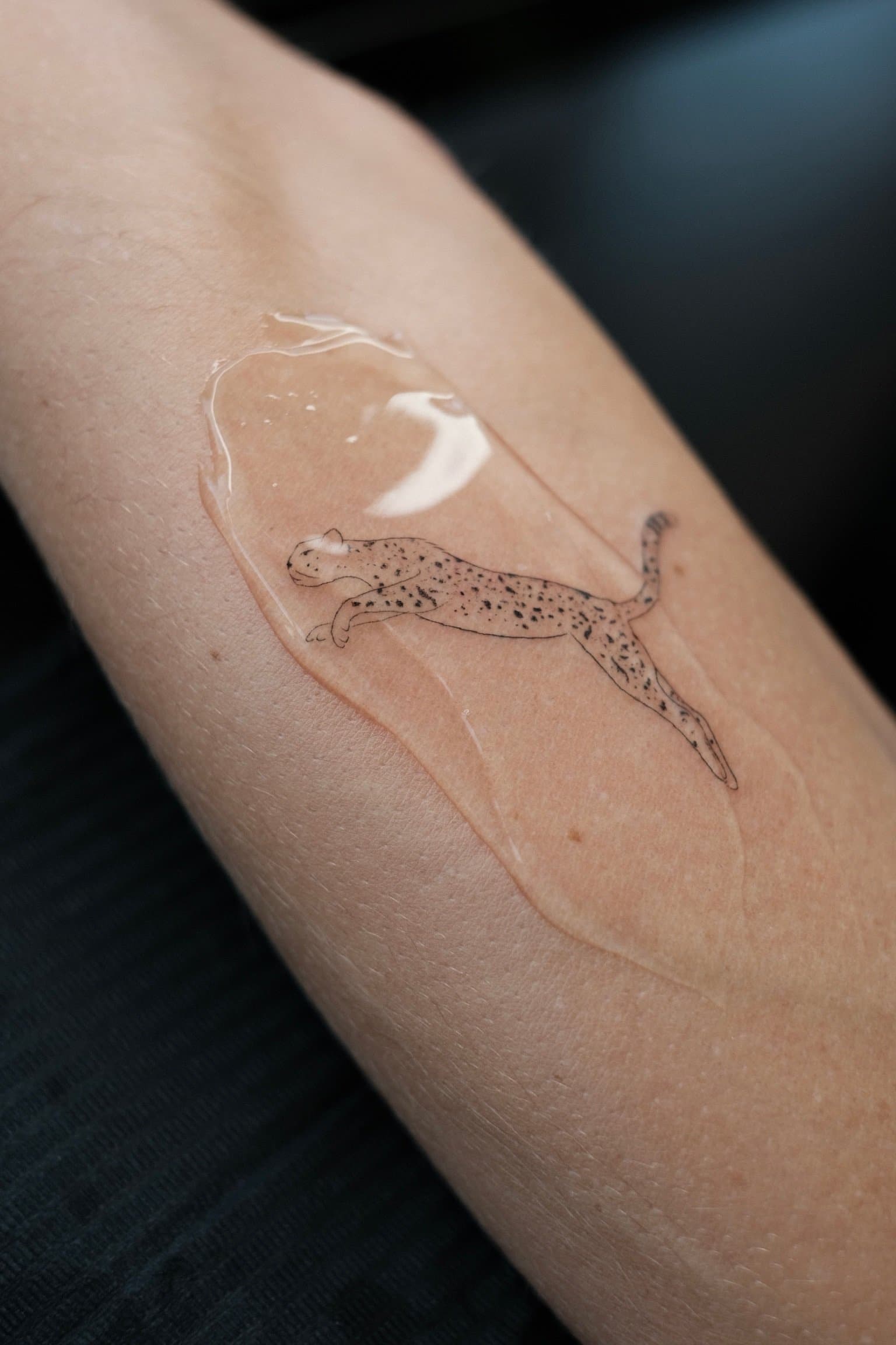 Fineline tattoo van een rennende cheeta op de onderarm.