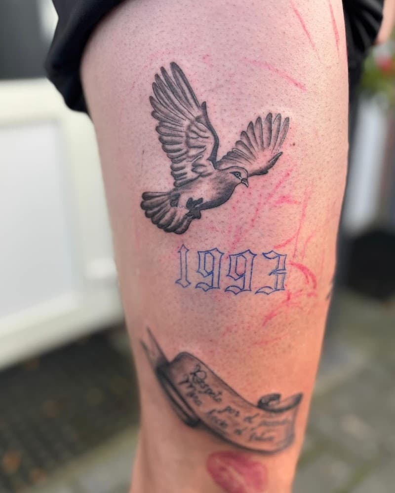 Zwart-wit duif, jaartal 1993 en een banier met tekst op het bovenbeen.