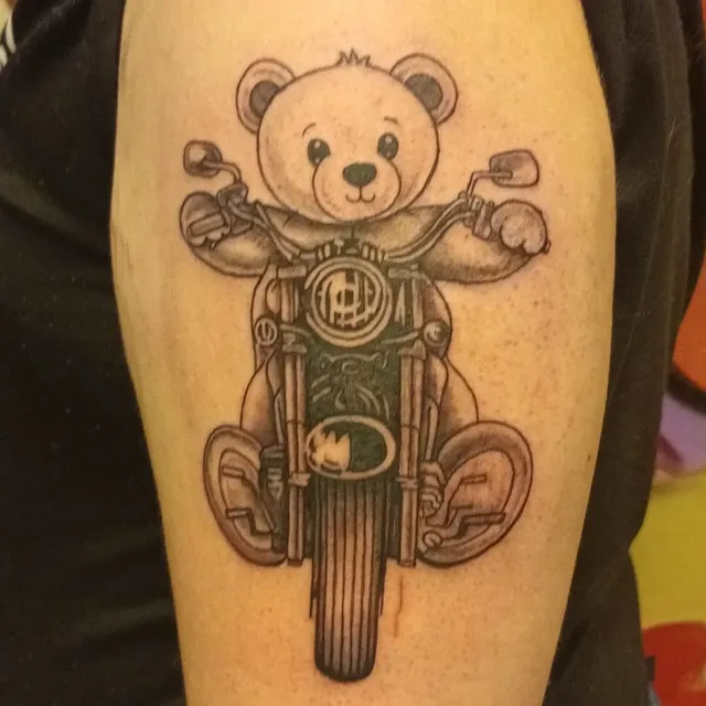 Illustratieve tattoo van een teddybeer op een motor.