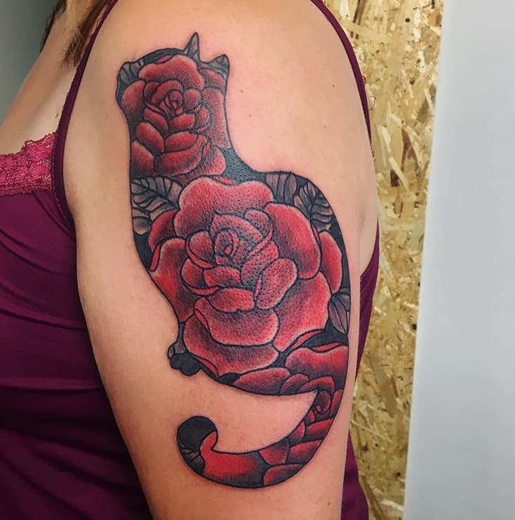 Kat silhouet gevuld met rode rozen op bovenarm.