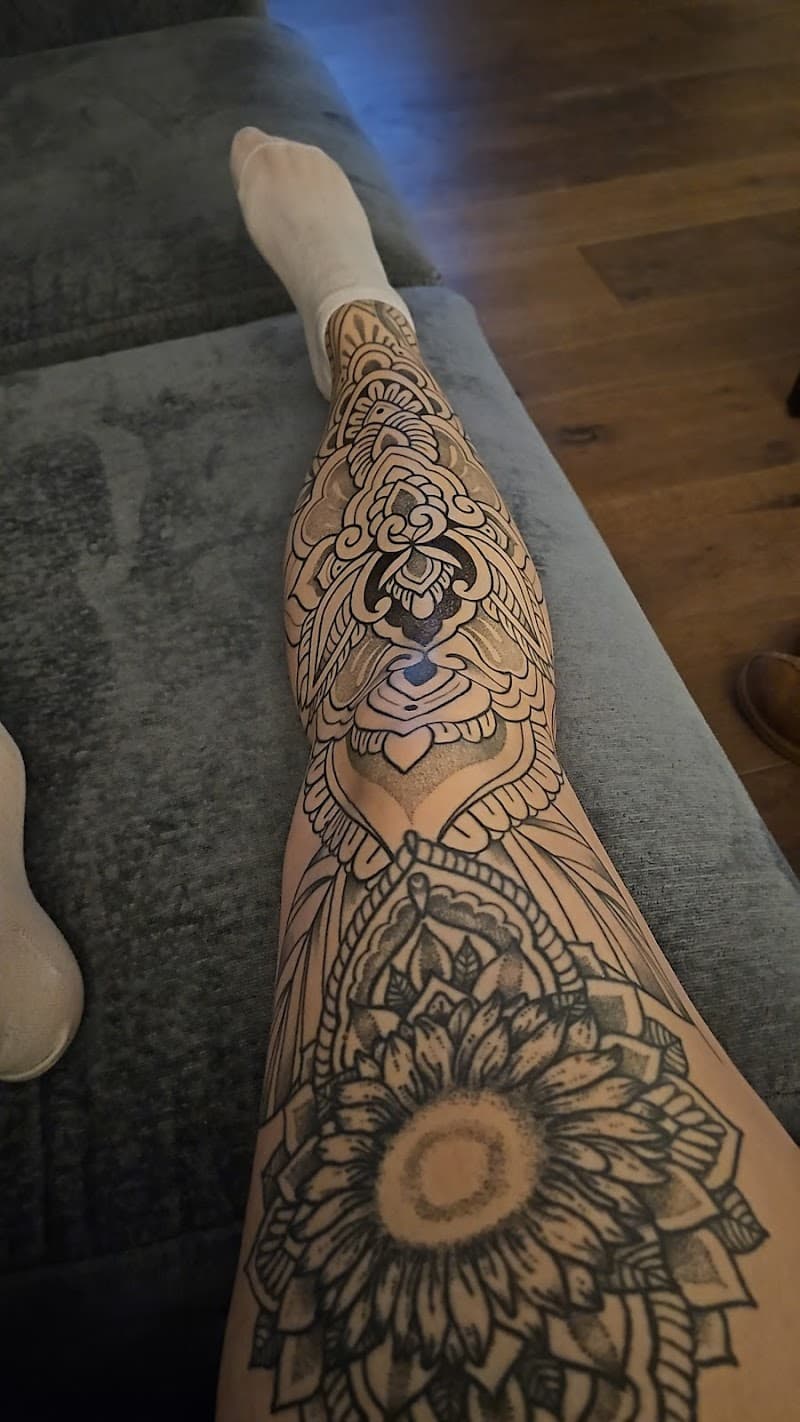 Grote mandala en bloemen tattoo op het hele onderbeen.