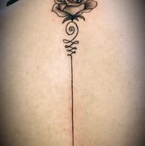 Fineline roos met unalome symbool op de rug.