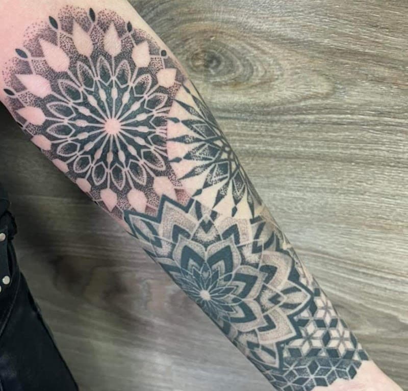 Grote geometrische dotwork mandala half-sleeve op onderarm.