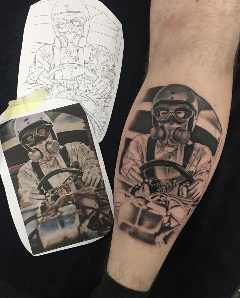 Realistische tattoo van een coureur met helm en gasmasker in een racewagen.