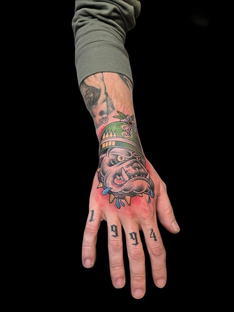 Neo-traditionele bulldog met helm op hand en '1994' op vingers.