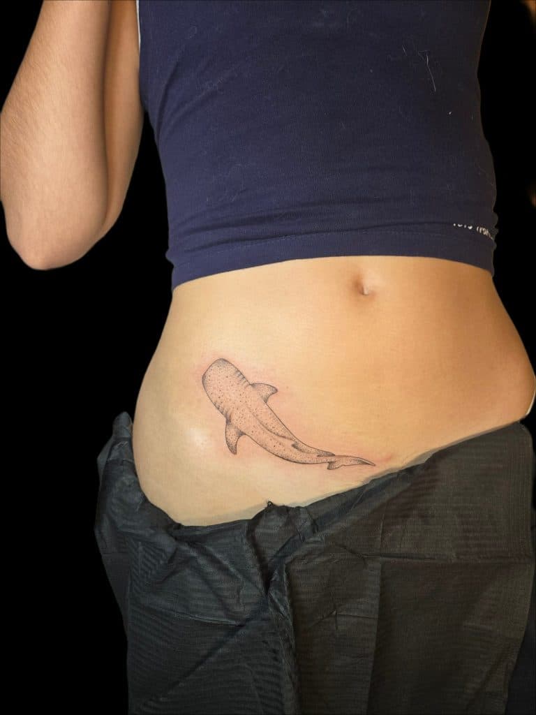 Fineline walvishaai tattoo op de heup.