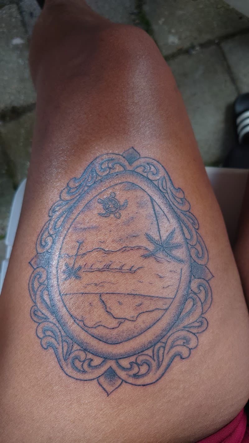 Linework tattoo van een strandscène met schildpad in een sierlijke lijst.