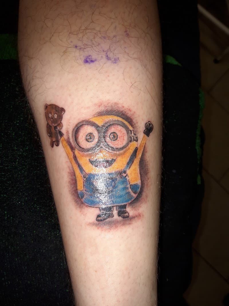 Kleurrijke Minion met teddybeer tattoo op onderbeen.