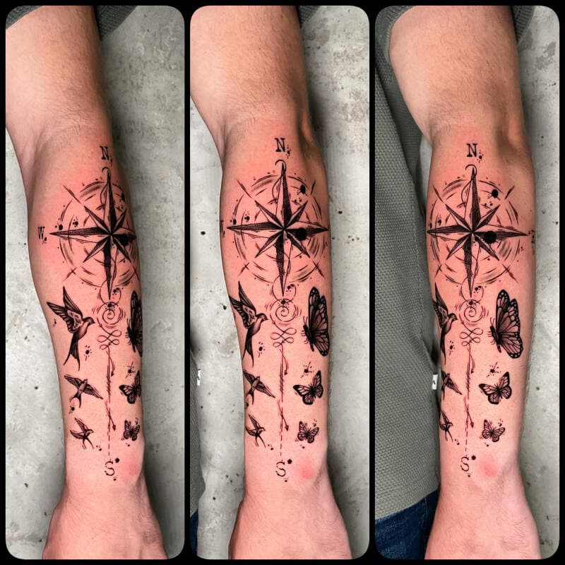 Blackwork kompasroos met vogels en vlinders op onderarm.