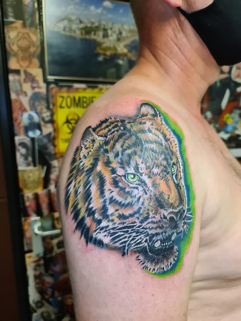 Realistische tijgerkop met groene ogen en een groene gloed op de schouder.