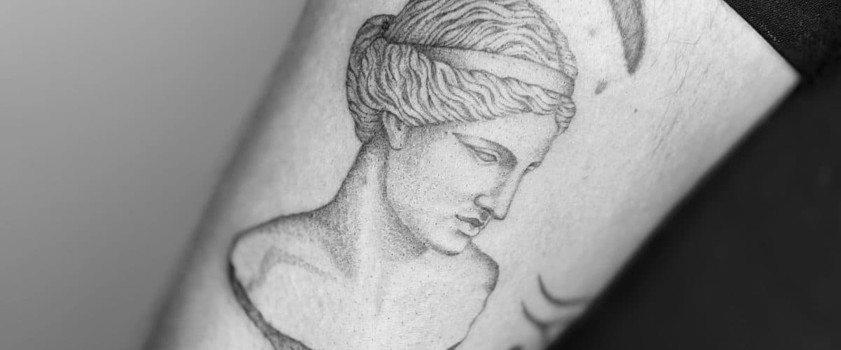 Gedetailleerde dotwork tattoo van een klassieke Griekse standbeeld buste.