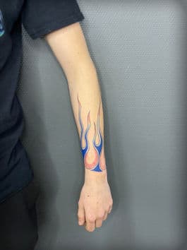 Blauwe en roze vlammen op de onderarm.