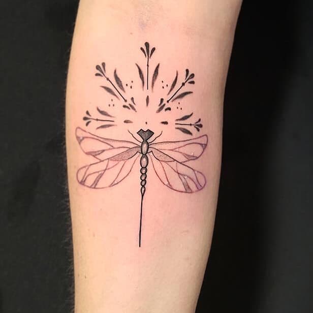 Fineline libelle met sierlijke ornamenten op de onderarm.