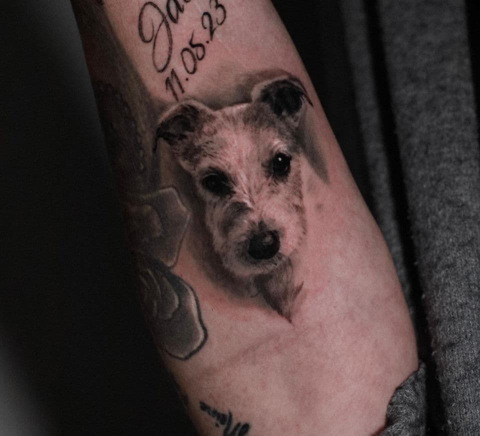 Realistisch portret van een ruwharige hond op de onderarm.