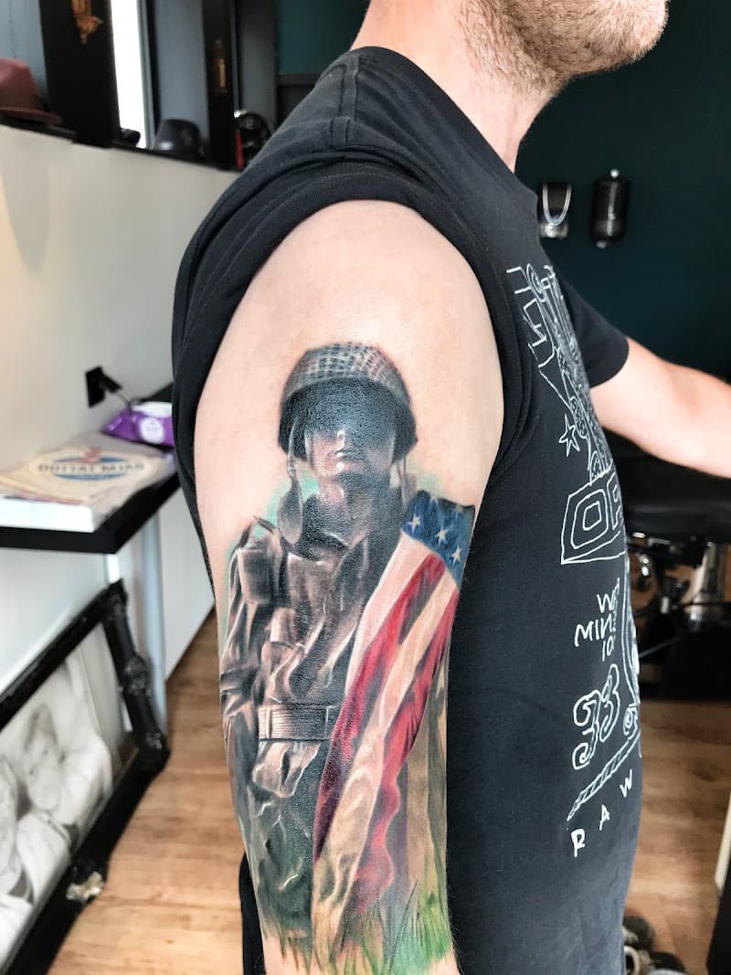 Realistische tattoo van een soldaat met Amerikaanse vlag op de bovenarm.