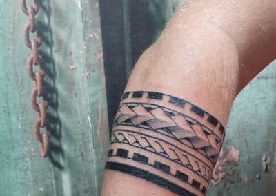 Polynesische tribal bandtattoo op de onderarm.