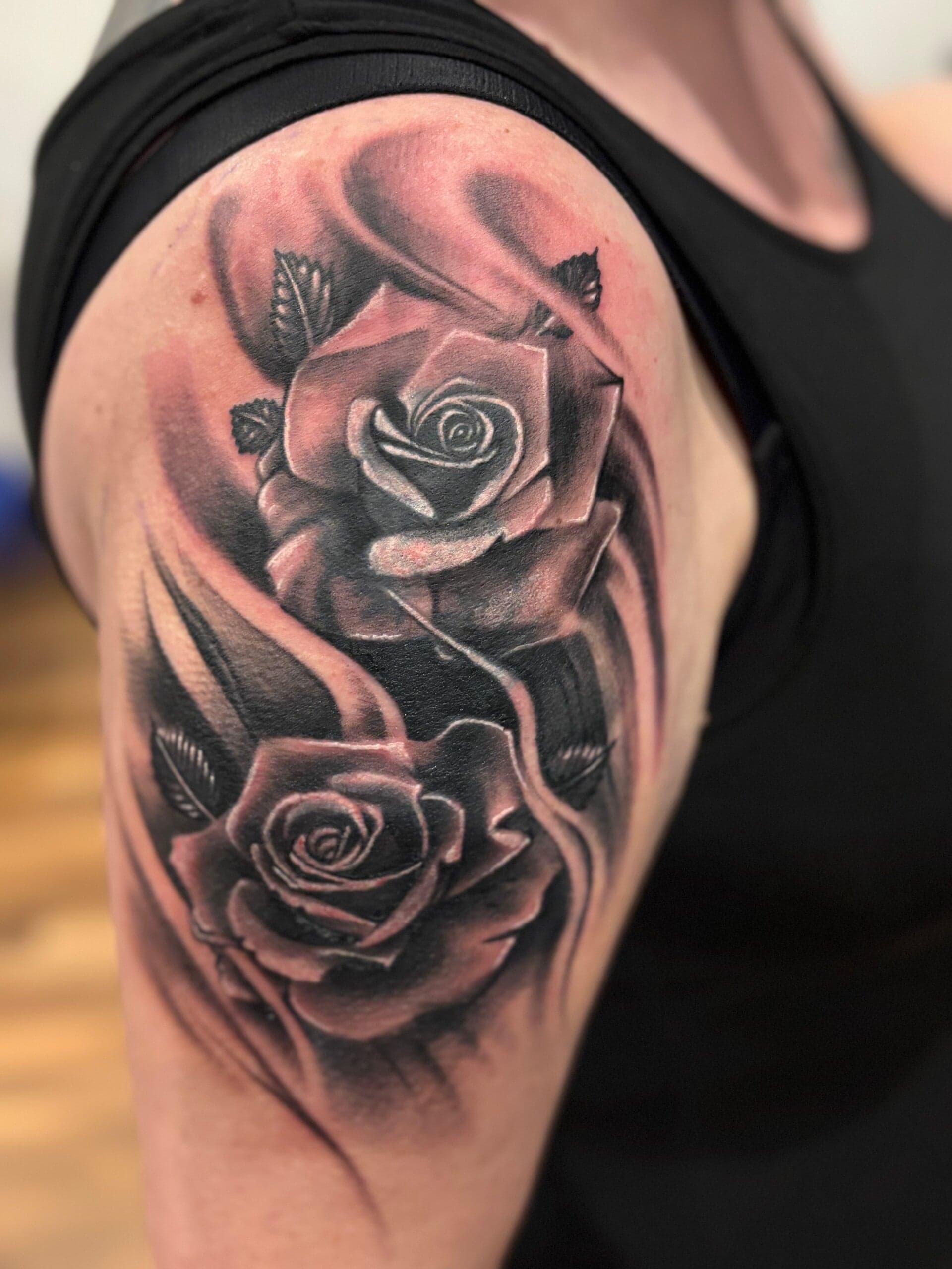 Twee realistische rozen met bladeren en schaduw op de bovenarm.