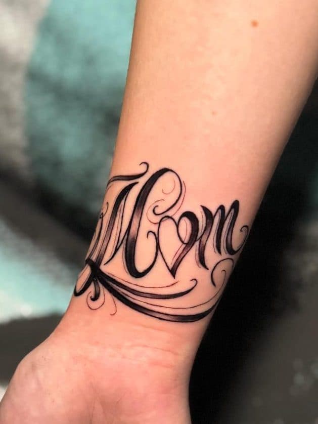 Sierlijke 'Mom' tekst met hartje op pols.