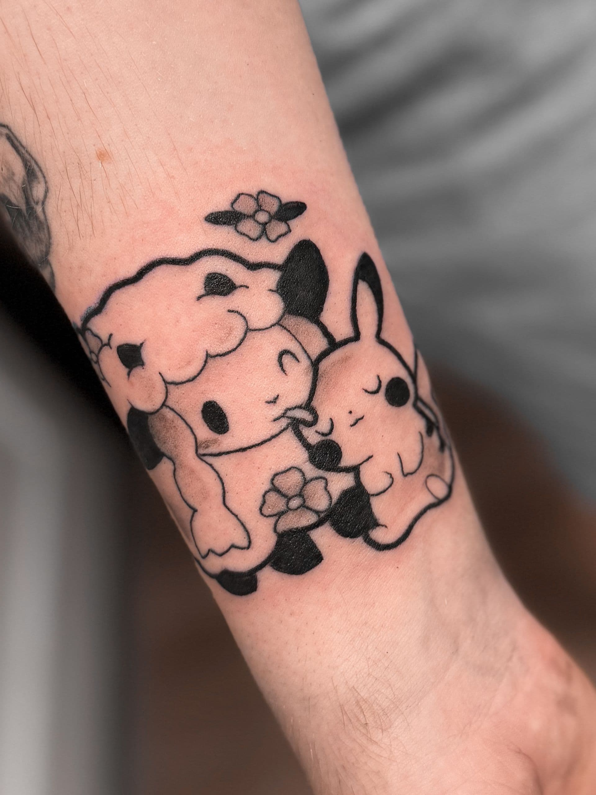 Schattige blackwork tattoo van een schaap en Pikachu die knuffelen.