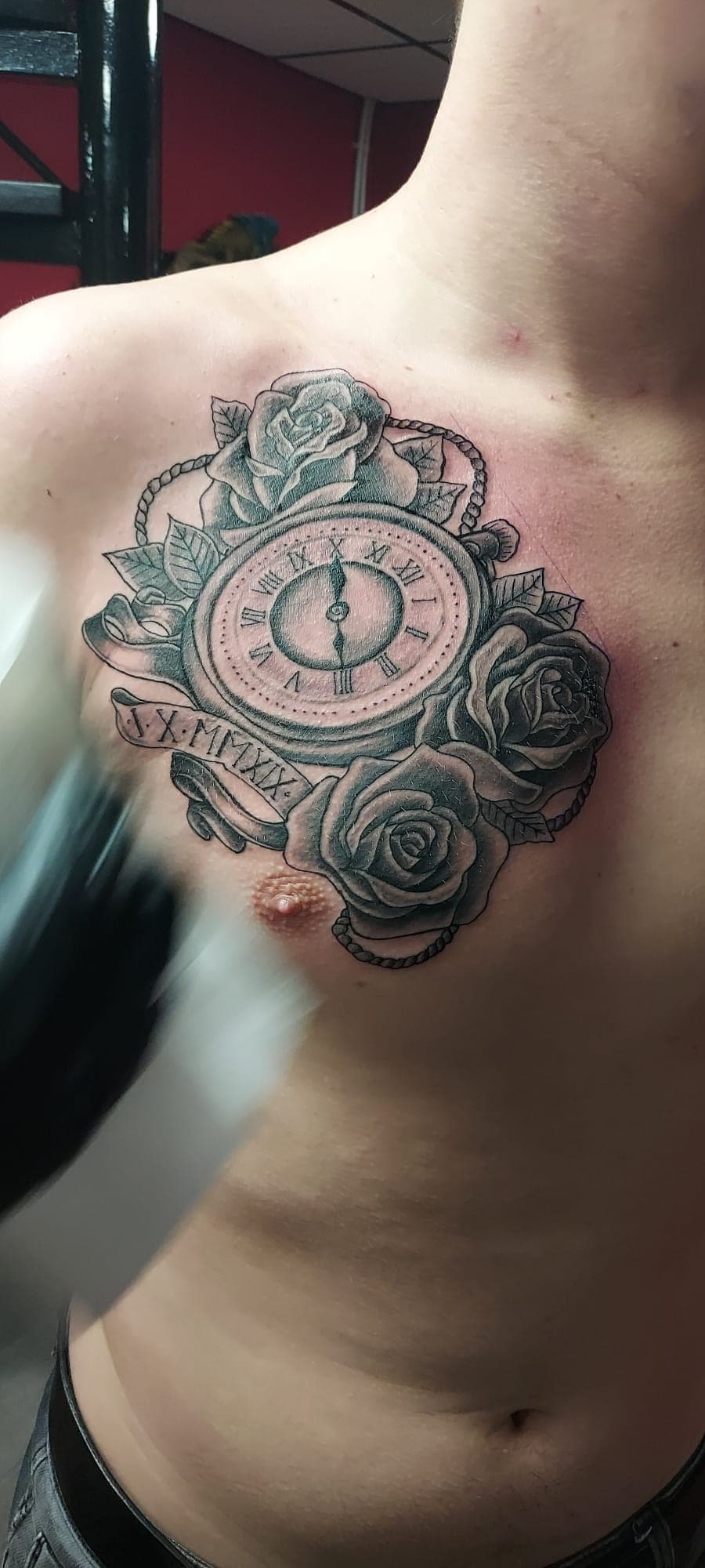 Zwart-wit borststuk met klok, rozen en Romeinse cijfers.