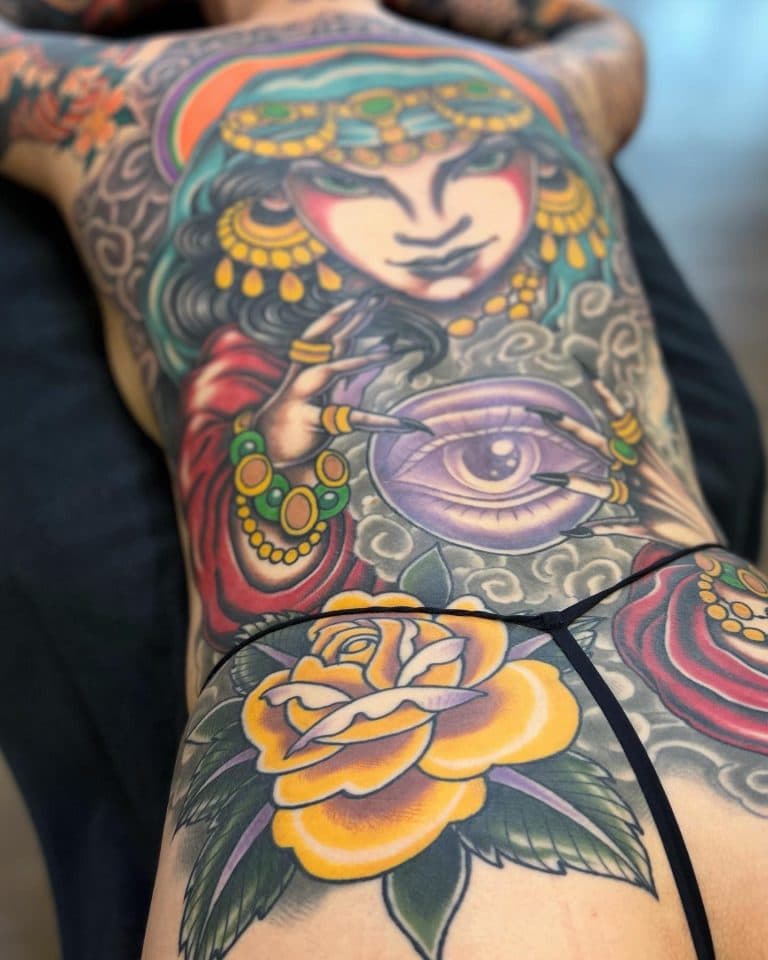 Grote neo-traditionele rugtattoo van een waarzegster met een glazen bol en een gele roos.