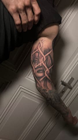 Realistisch portret van een vrouw achter een hekwerk op de bovenarm.