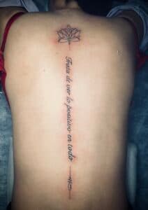 Fineline lotus, Spaanse tekst en unalome op de ruggengraat.