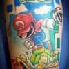 Kleurrijke Super Mario tattoo die een blok kapot springt.