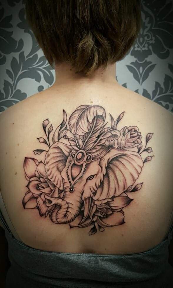 Grote olifant met veren en bloemen op de bovenrug.