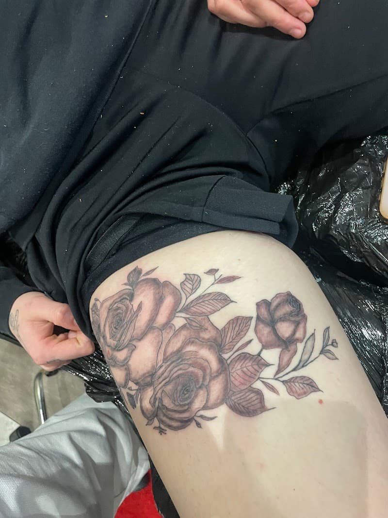 Realistische zwart-grijze rozen met bladeren op het bovenbeen.