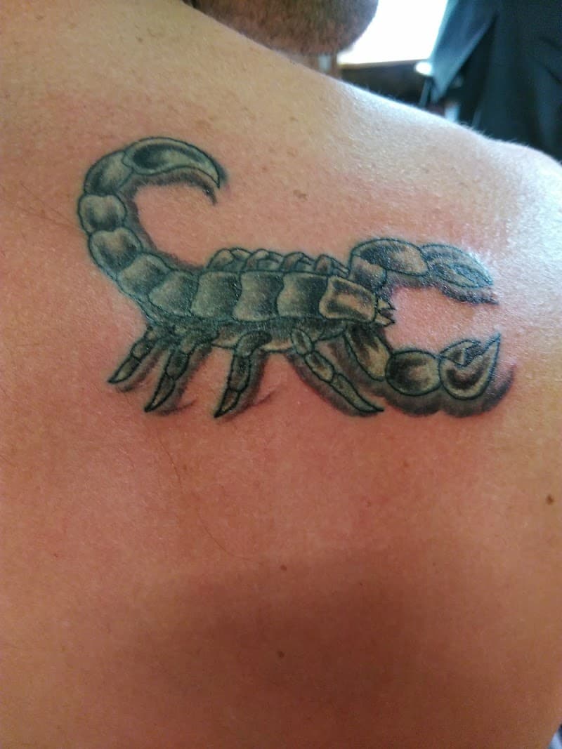 Realistische schorpioen tattoo op schouderblad.