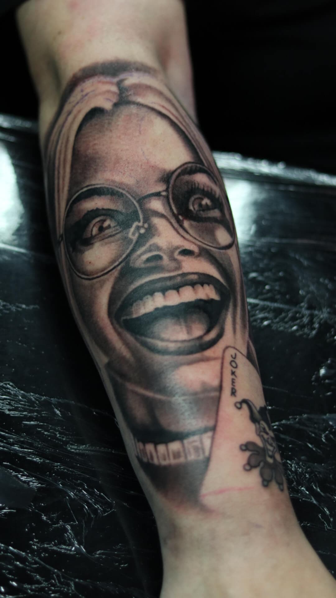 Realistisch portret van lachende vrouw met bril en een Joker kaart.