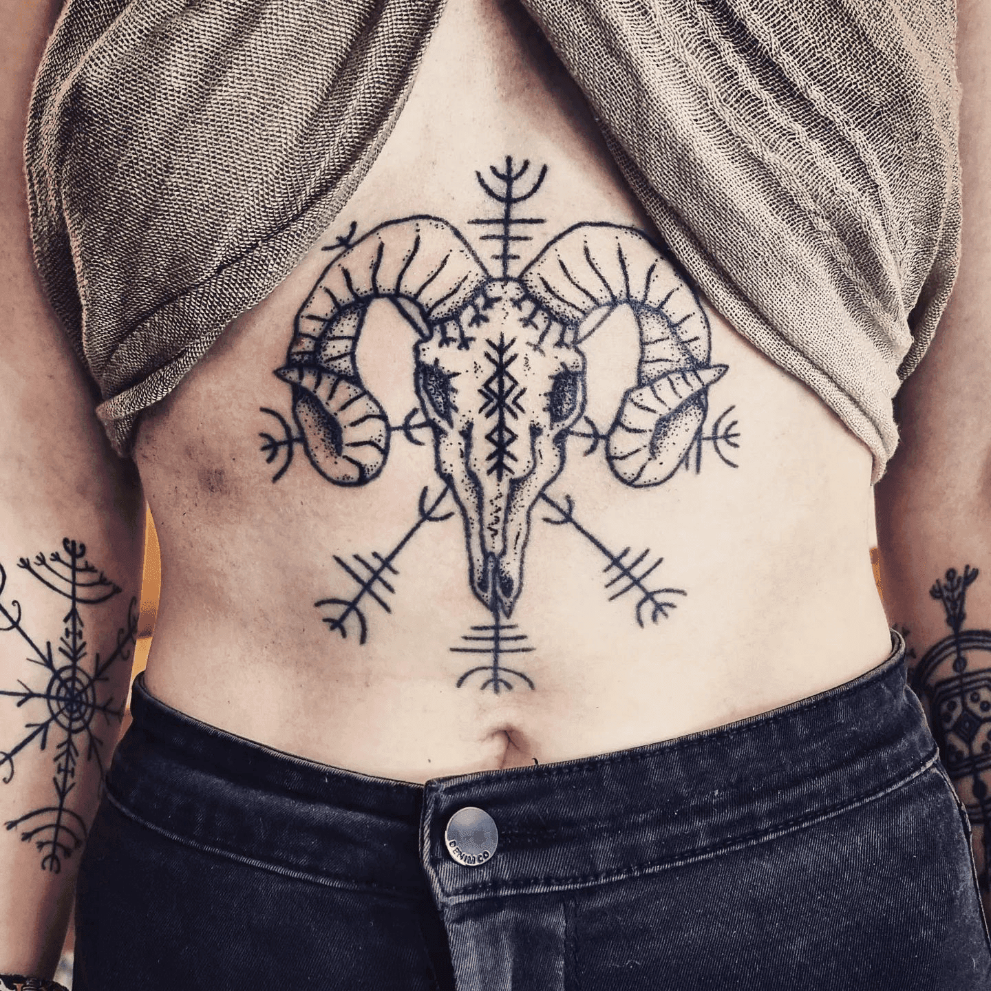 Ram schedel met runen en symbolen op de buik.