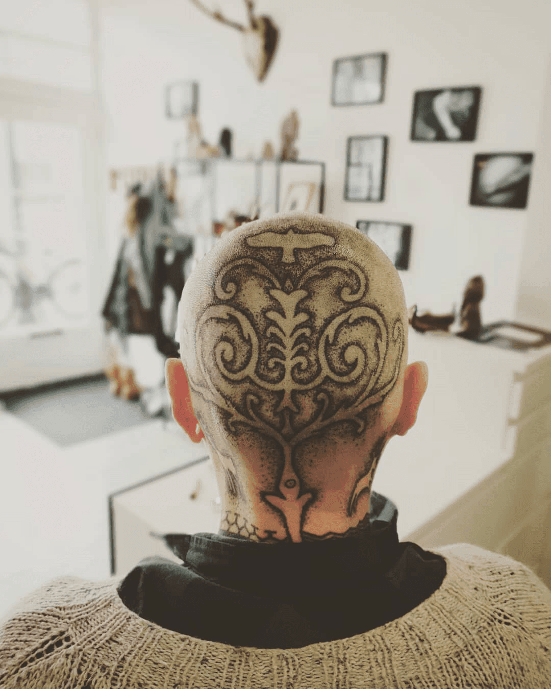 Grote ornamentale dotwork tattoo op het achterhoofd en de nek.