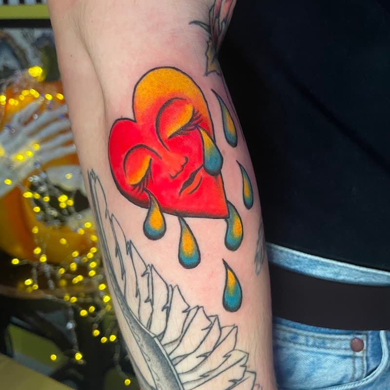 Kleurrijk huilend hart met gezichtje op de bovenarm.