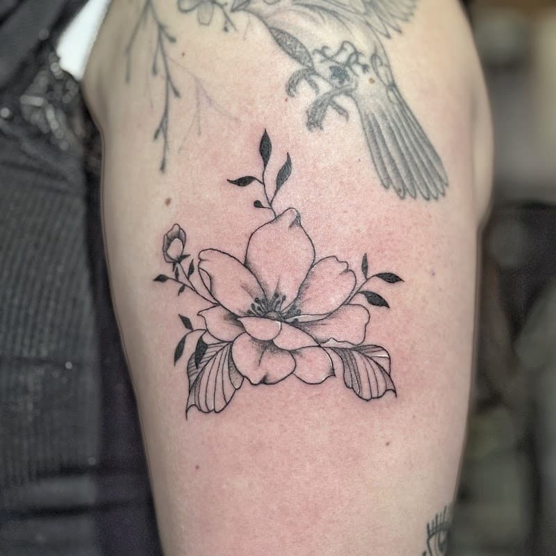 Fineline bloem met bladeren op de bovenarm.