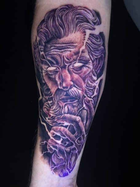 Realistische Zeus tattoo met bliksem en paarse gloed op onderarm.