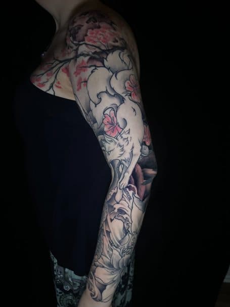 Japanse sleeve tattoo met witte kitsune en kersenbloesem.