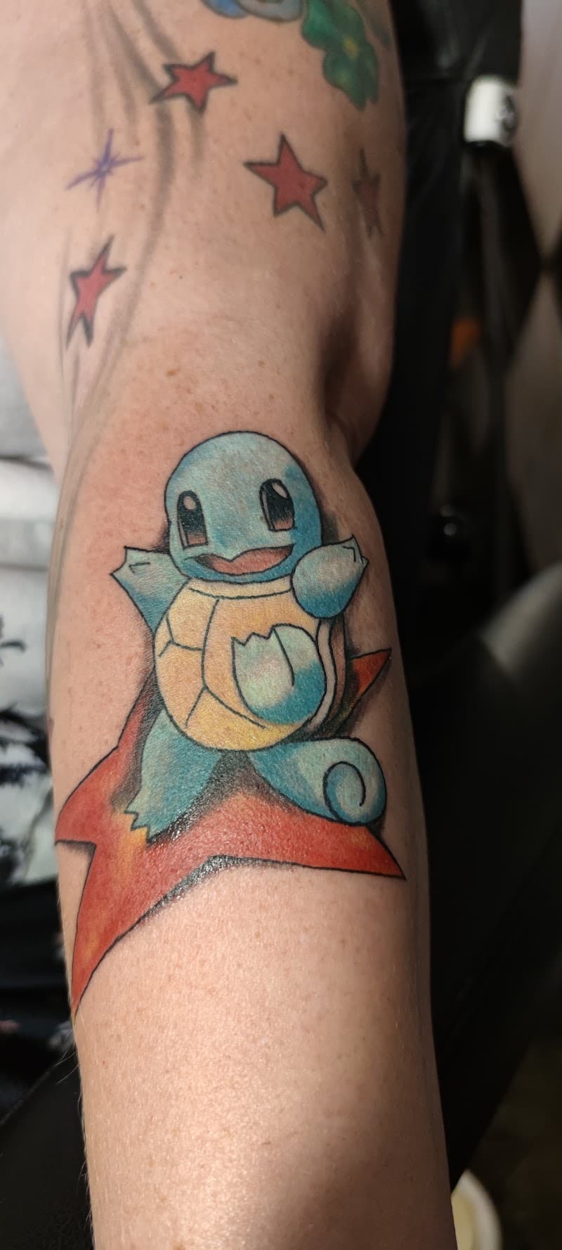 Kleurrijke Squirtle Pokémon tattoo zittend op een rode ster.