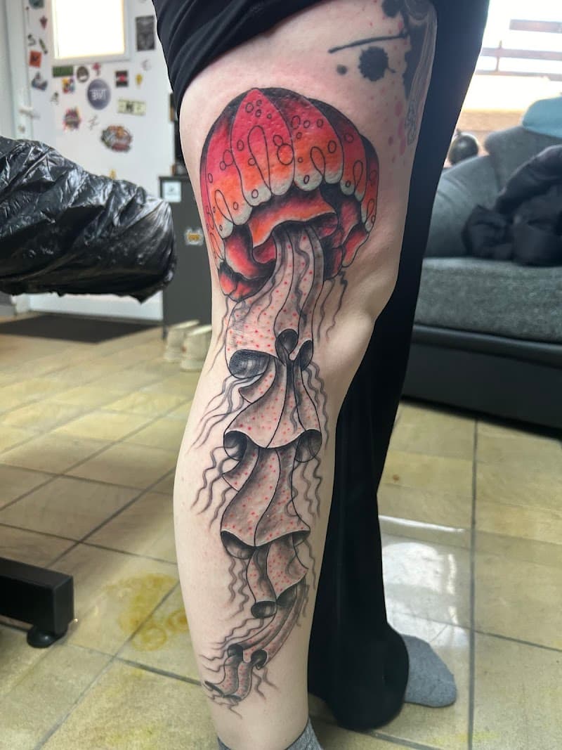 Grote, kleurrijke kwal tattoo op het onderbeen.